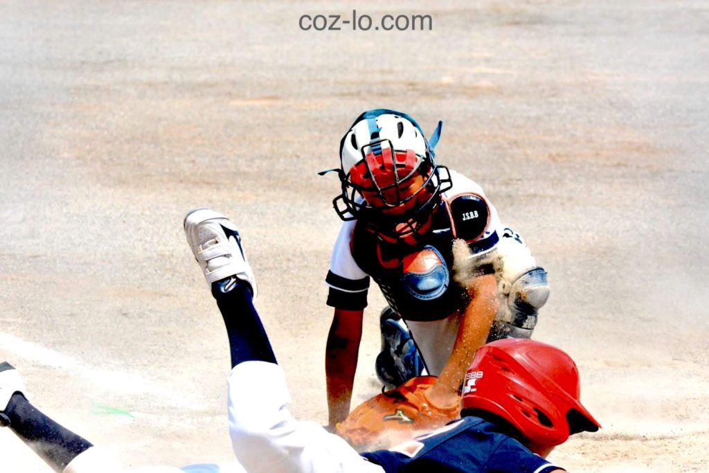 ホームインしようとするランナーにタッグするキャッチャー