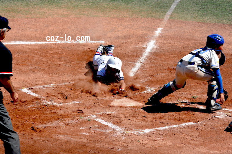 必死にヘッドスライディングをするランナー